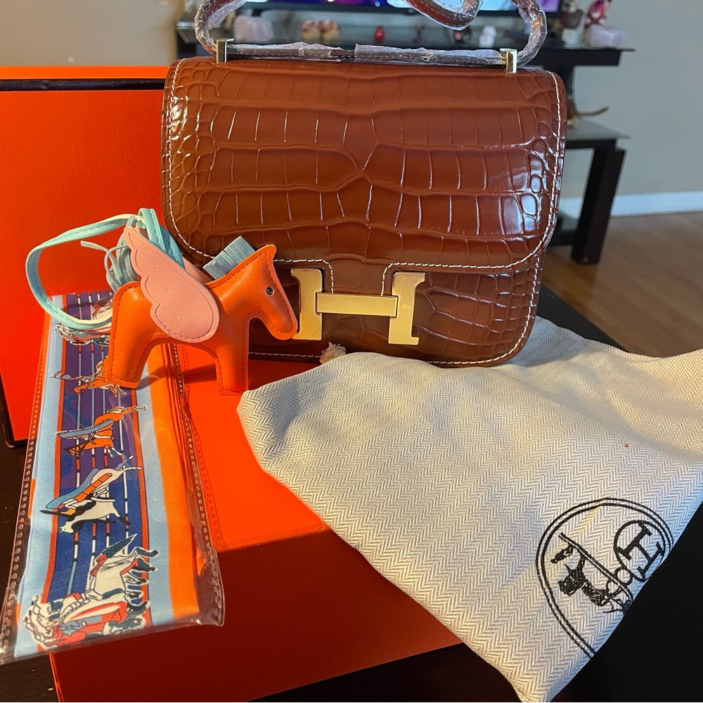 Constance H., crossbody 19cm. Cowhide, shiny Alligator pattern in dark caramel.